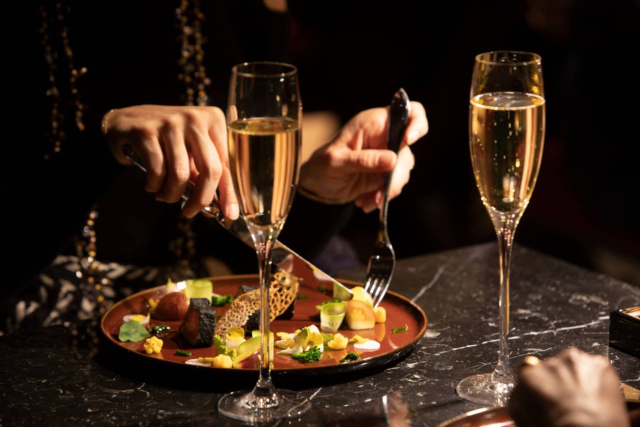 Couple enjoying a romantic dinner with champagne at a Paris restaurant.