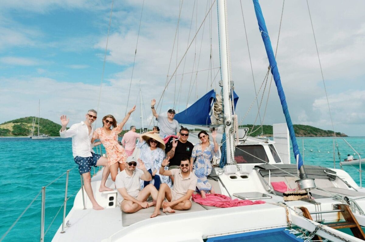 Group of people enjoying a sunny day on a sailboat in turquoise waters