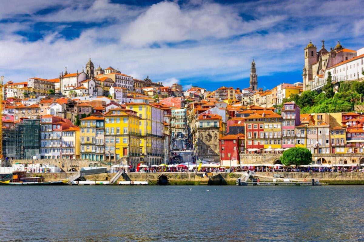 Colorful Porto buildings along the Douro River under a vibrant sky