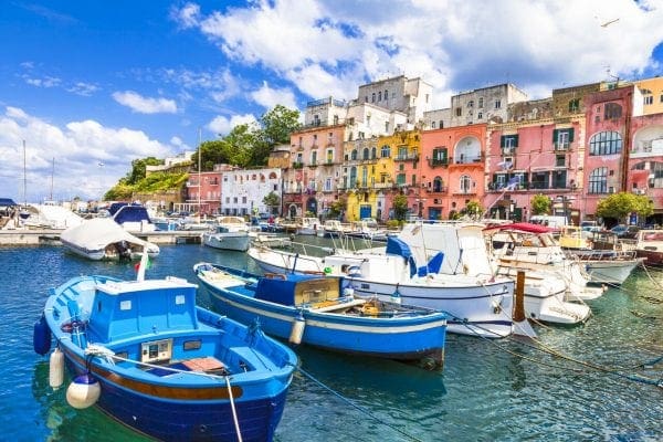 Colorful seaside village with boats docked in the harbor under a blue sky