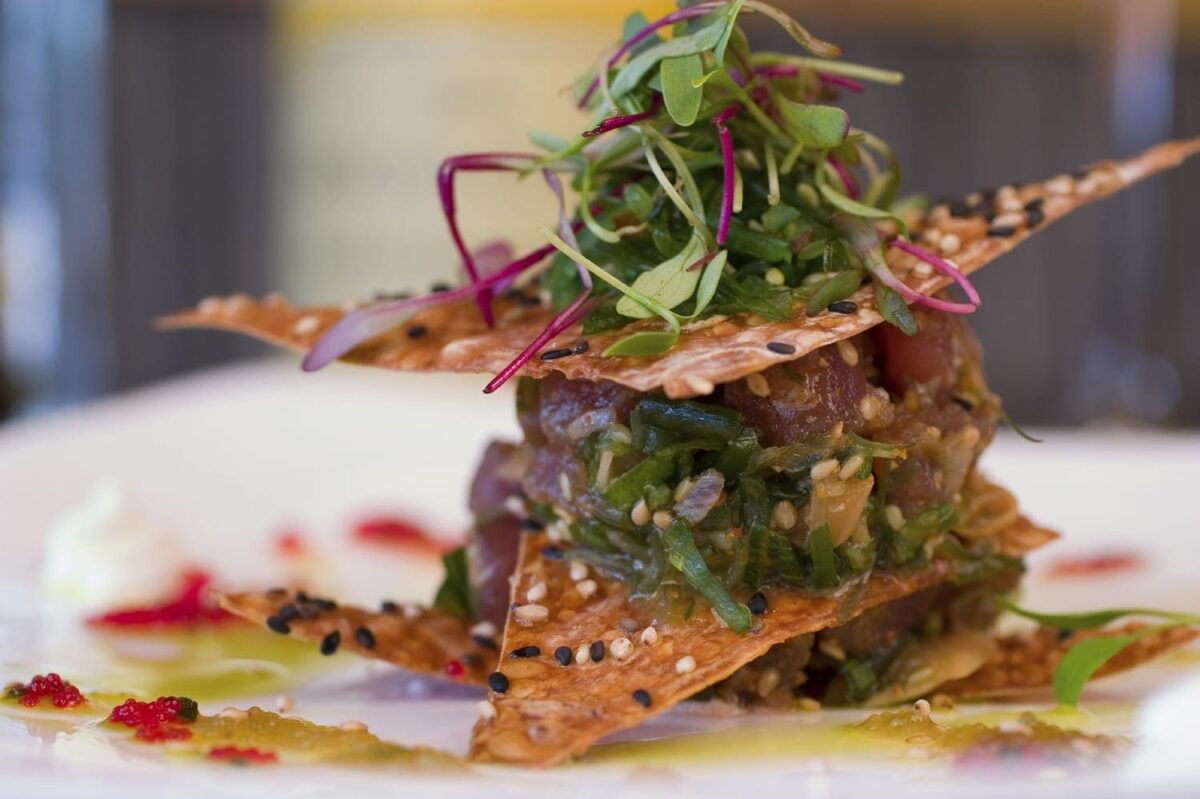 Gourmet wedding reception dish with tuna, greens, and crispy wafers