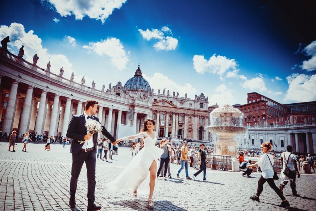 Couple in wedding attire at St. Peter's Square, Rome, with Vatican backdrop
