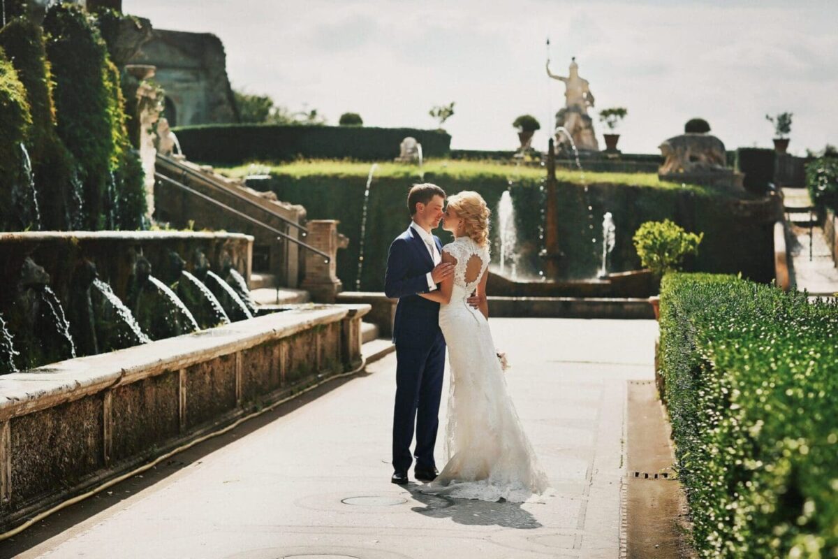 Bride and groom embracing in a garden with fountains at a Rome wedding venue