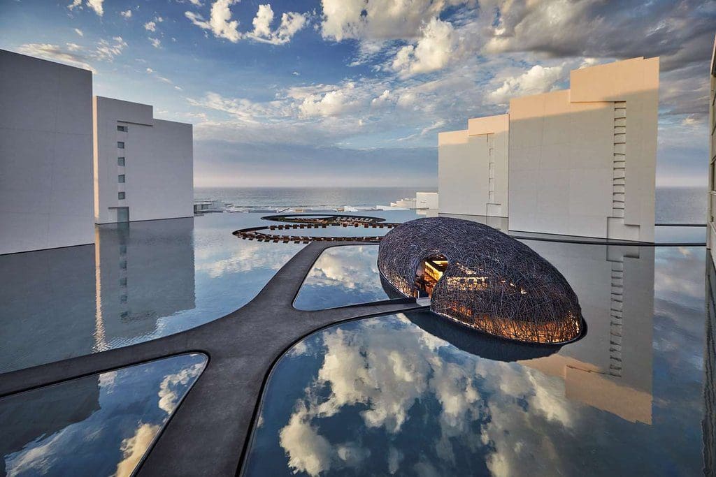 Modern Los Cabos resort with sleek architecture and water reflection