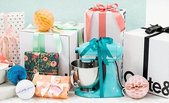 Colorful wedding guest gifts with ribbons and mixer on table