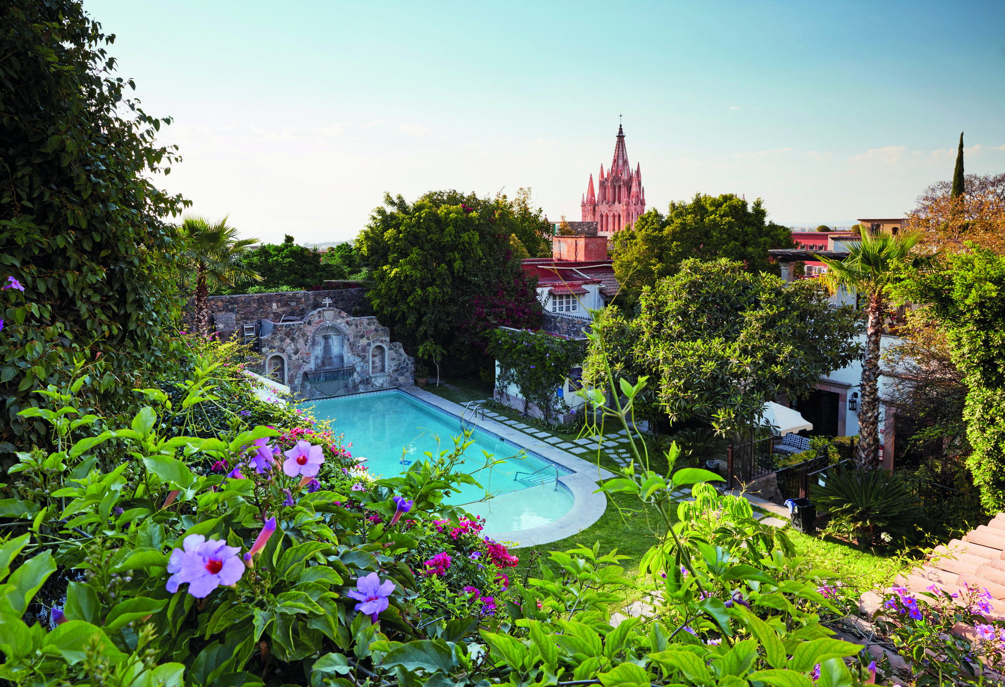 Casa de Sierra Nevada pool with floral garden and distant church view