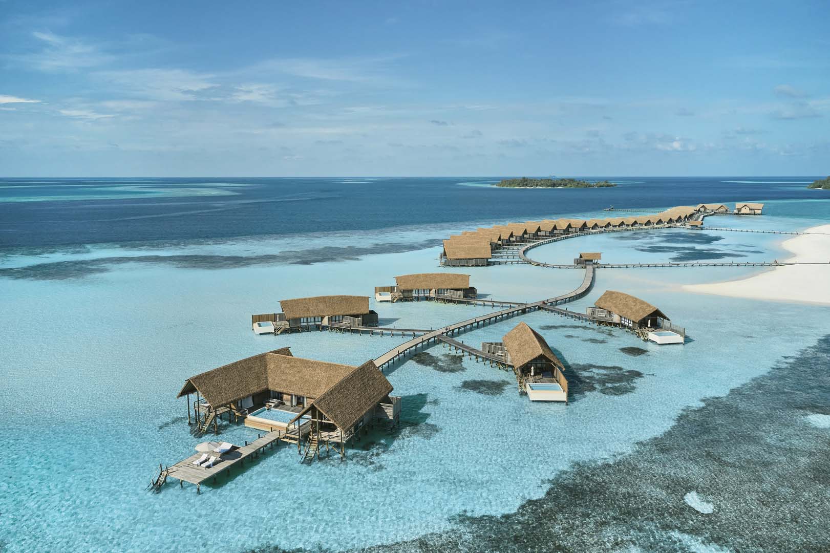Overwater villas at COMO Cocoa Island, Maldives under clear skies