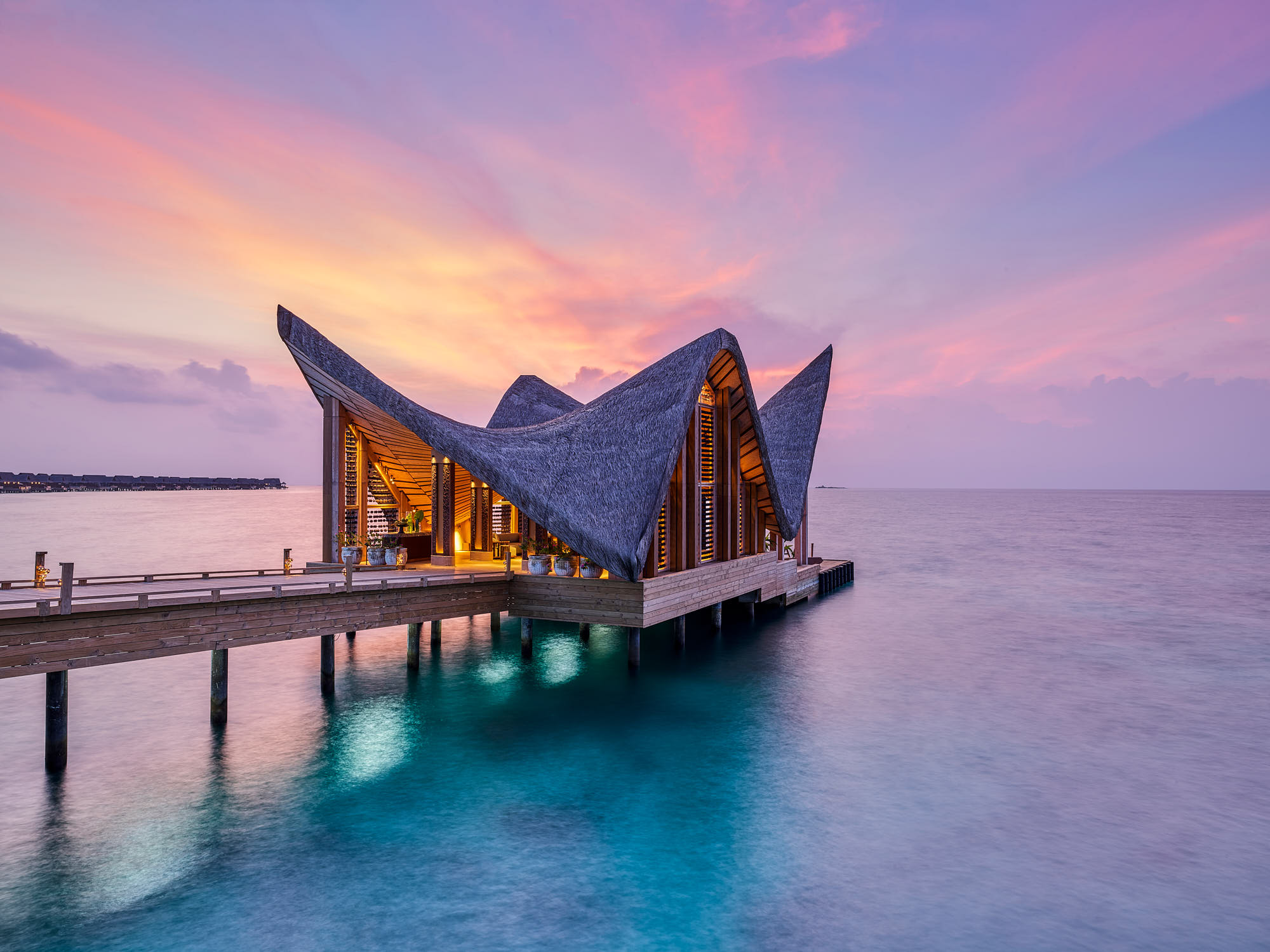 Sunset view of Joali Maldives resort over water