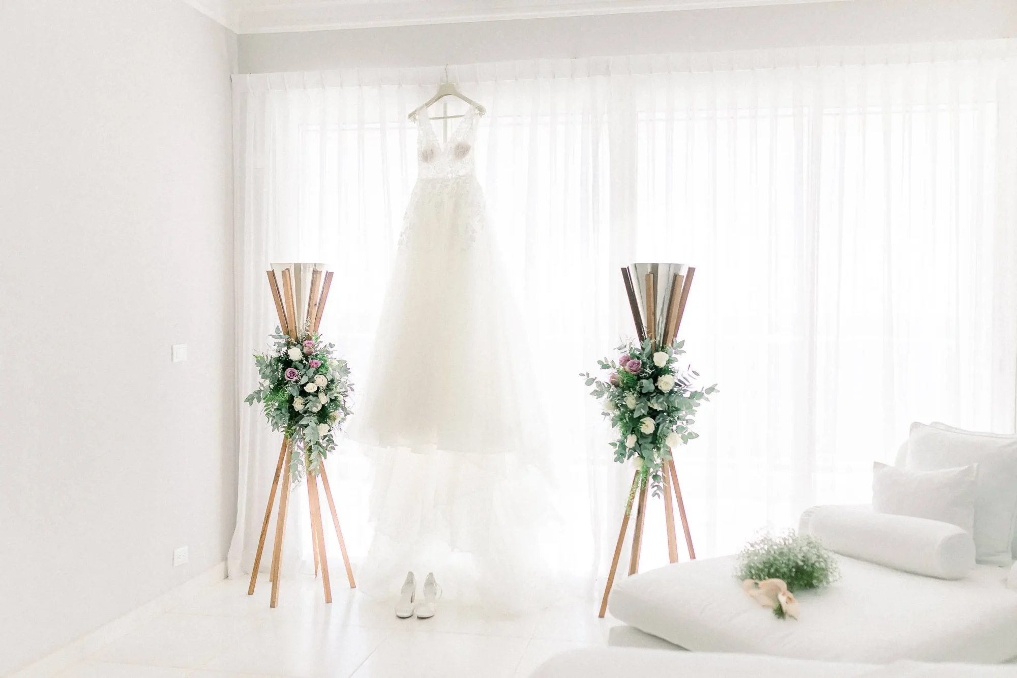 Wedding dress hangs near floral displays at Boutique Hotel Casa Hemingway in the Dominican Republic.