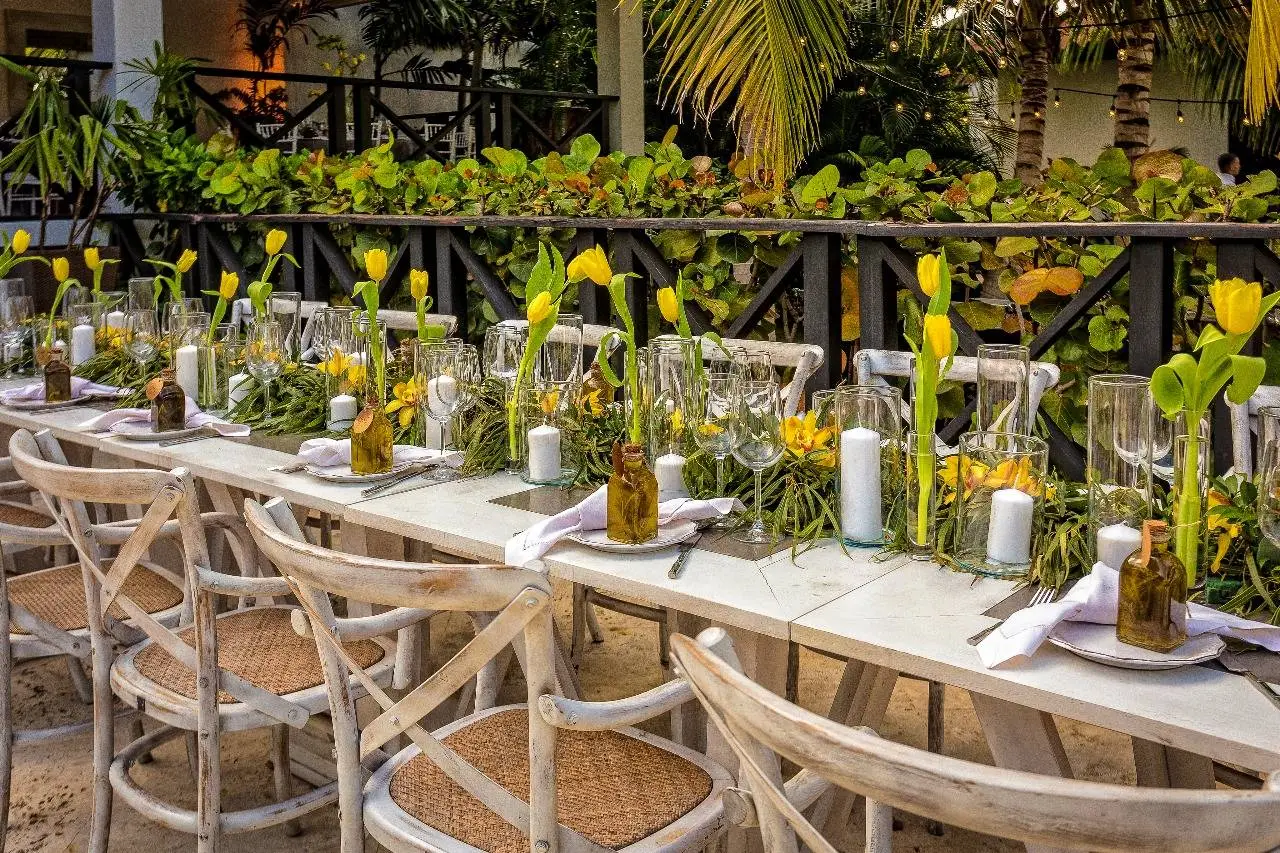 Elegant outdoor wedding reception table at Boutique Hotel Casa Hemingway in the Dominican Republic. Yellow tulips and candles decorate the rustic table setting.