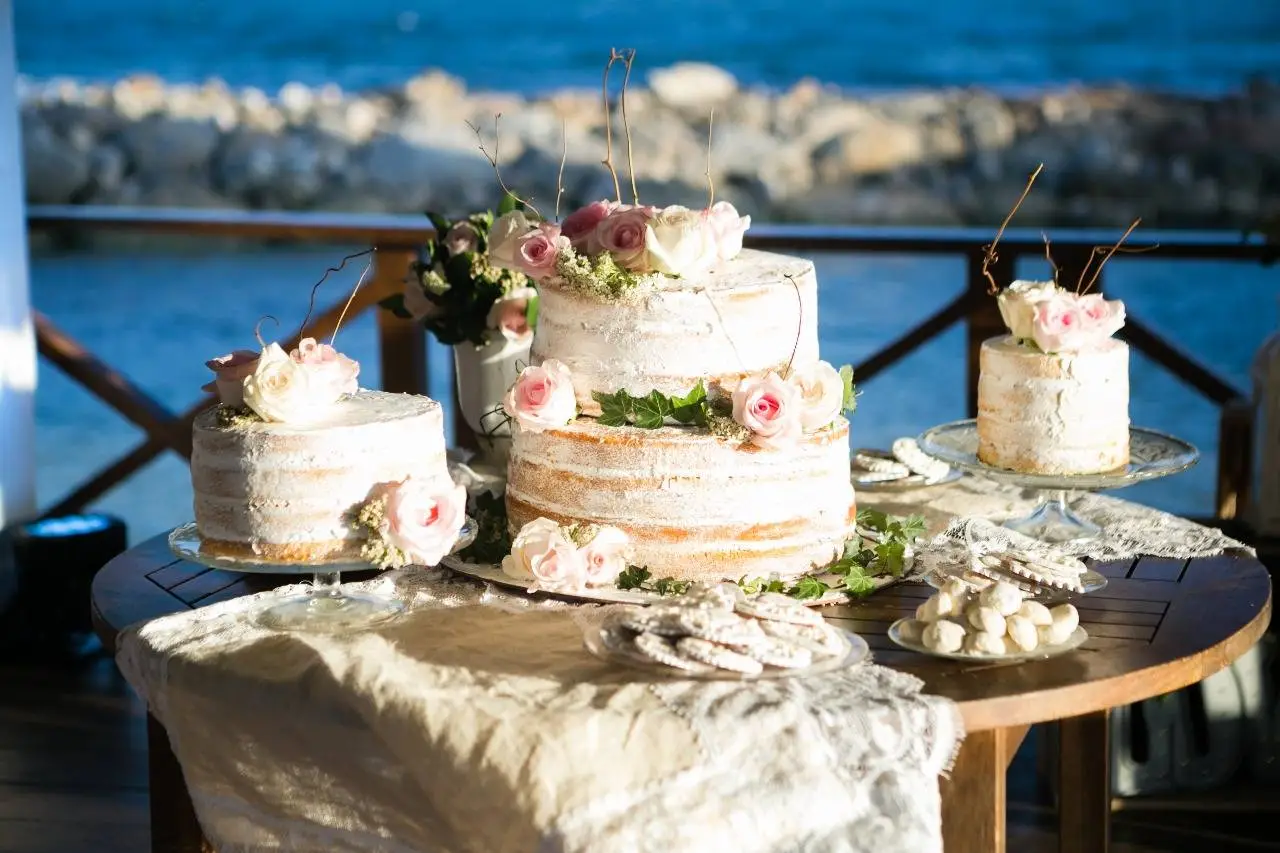 Three-tiered wedding cake with pink roses, decorated for a Dominican Republic wedding at Boutique Hotel Casa Hemingway.