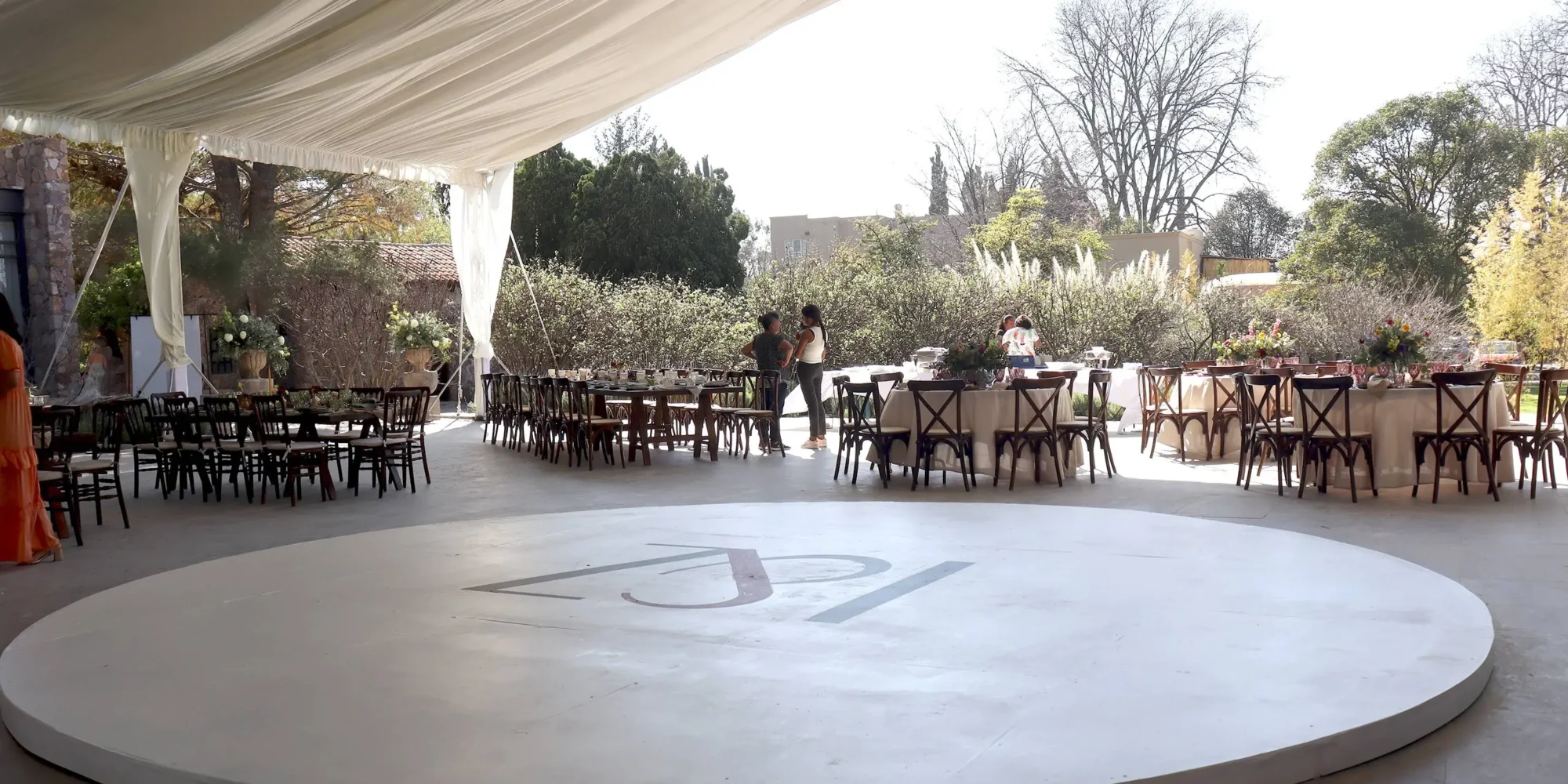 Elegant outdoor wedding reception in Mexico, featuring a circular dance floor with initials 