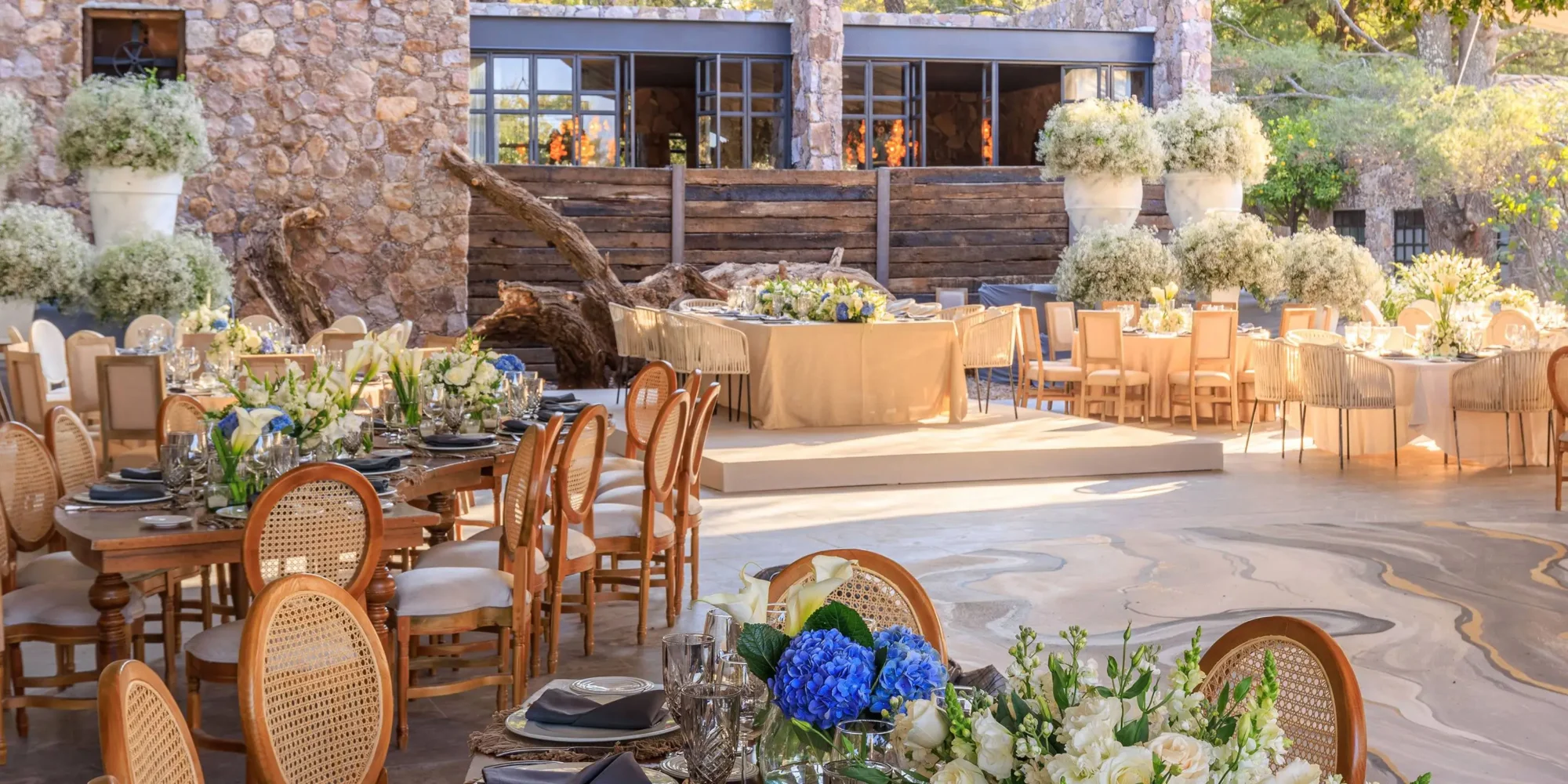Elegant outdoor wedding reception at Agua Bendita, Mexico. Tables adorned with floral centerpieces.