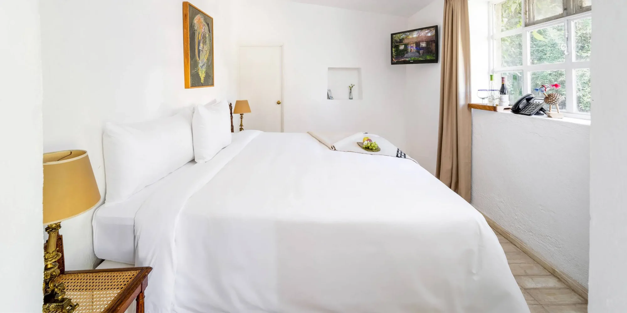 Luxurious Mexican hotel room with white bedding, ready for a dream wedding in Mexico.