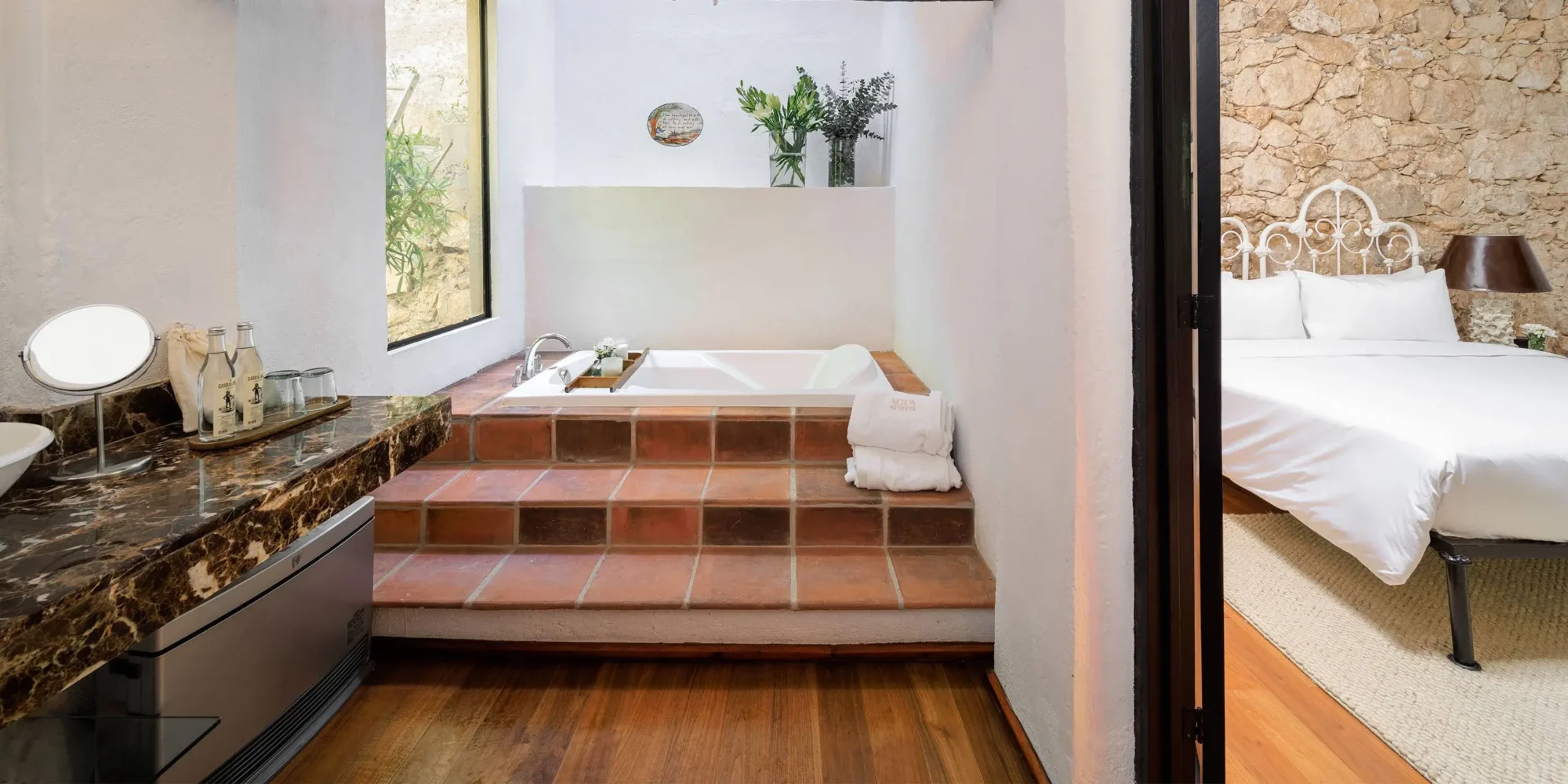 Luxurious Mexican hotel bathroom with soaking tub and view of bedroom. Dream wedding in Mexico.