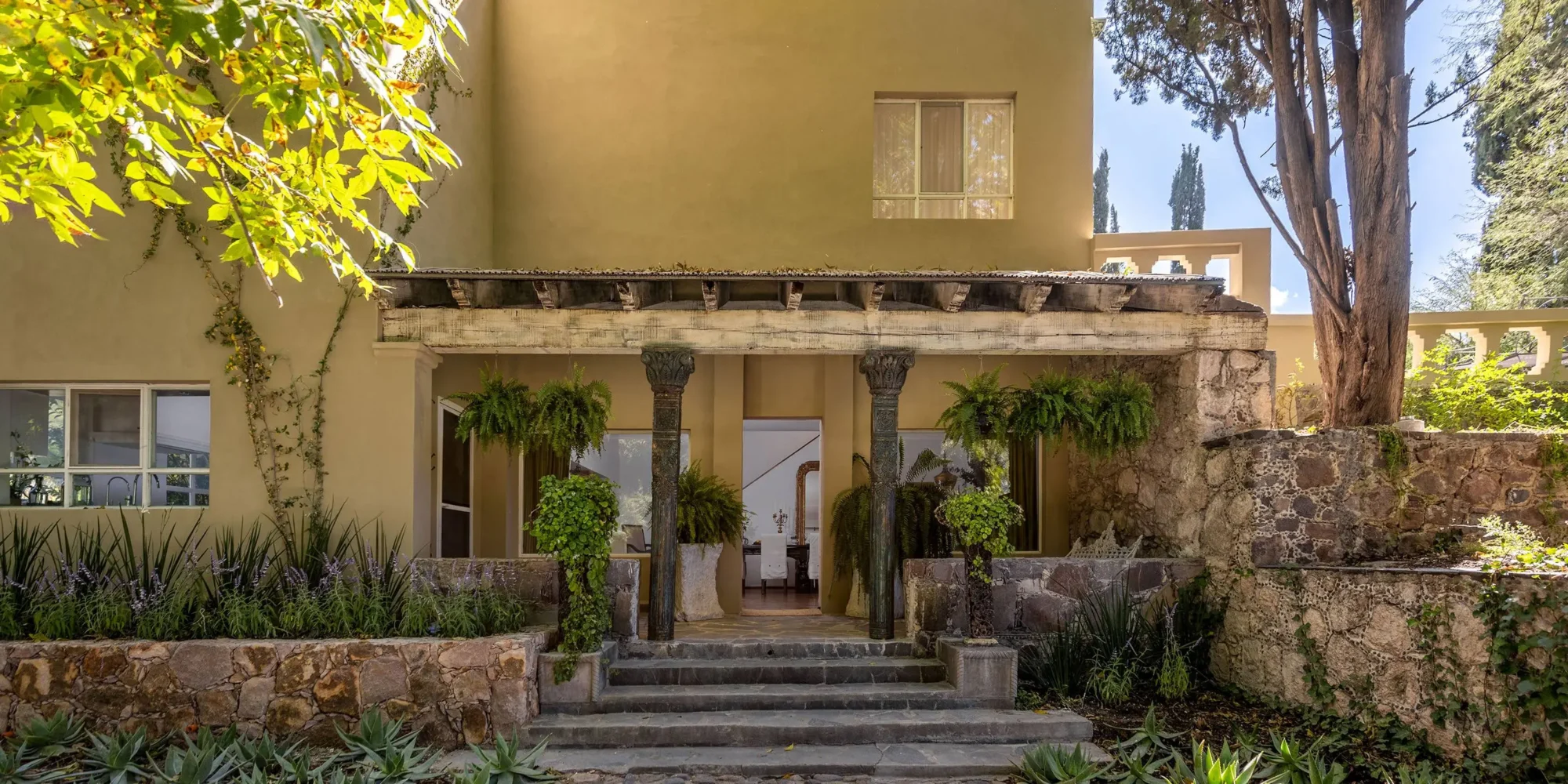 Stone steps lead to a Mexican hacienda's entrance, perfect for a dream wedding in Mexico at Agua Bendita.