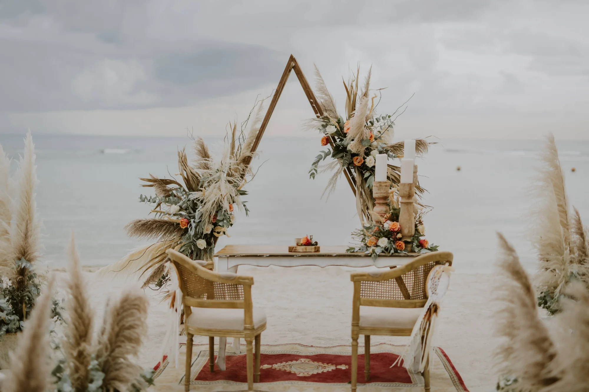 Beach wedding ceremony setup with pampas grass and floral arch. Dominican Republic wedding.
