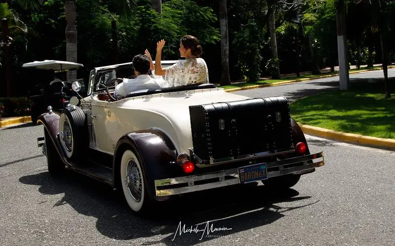 Happy couple in vintage car, Dominican Republic wedding.