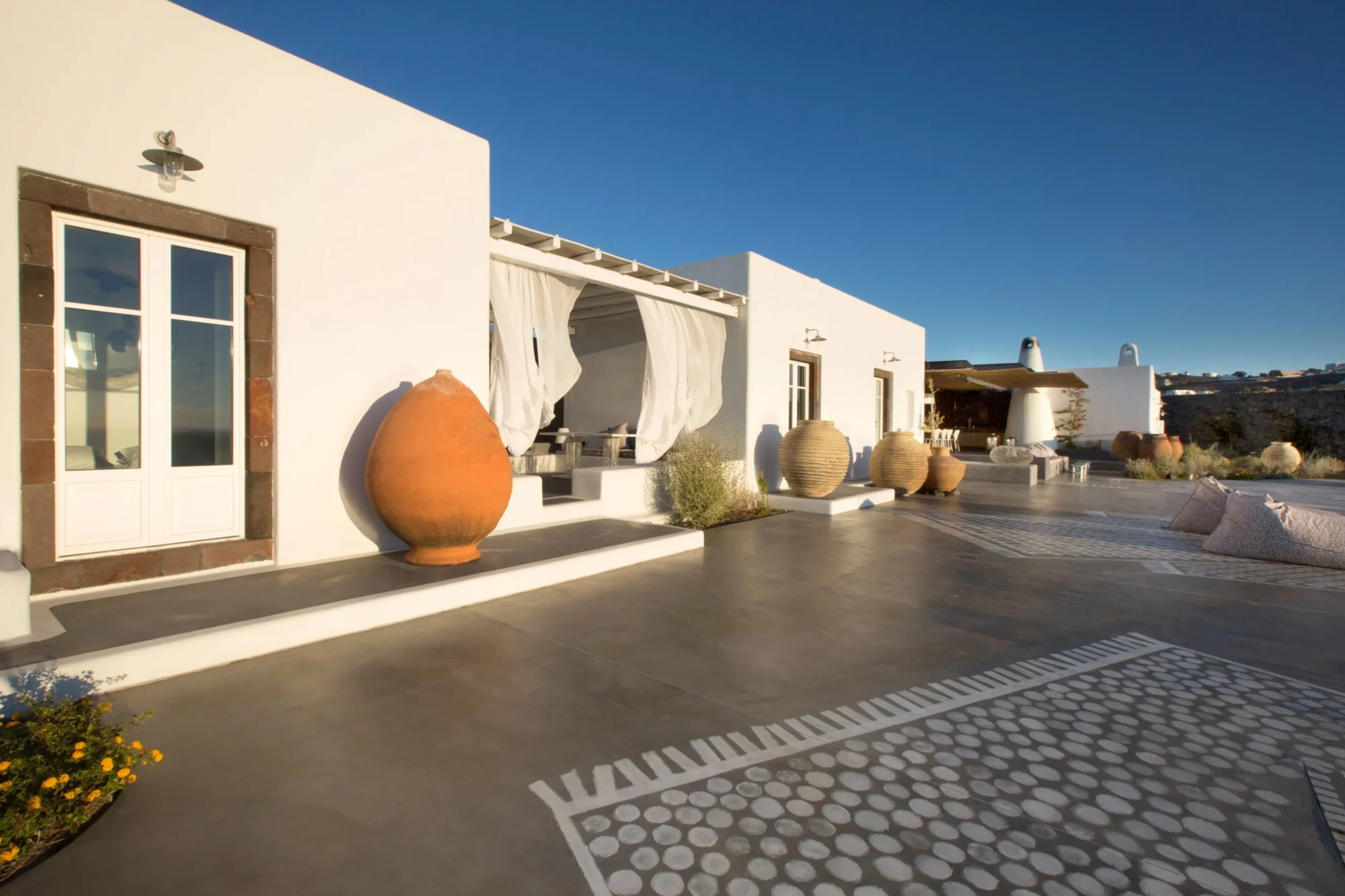 Santorini villa with whitewashed walls, terracotta pots, and a tranquil patio. Perfect for a dream wedding in Santorini.
