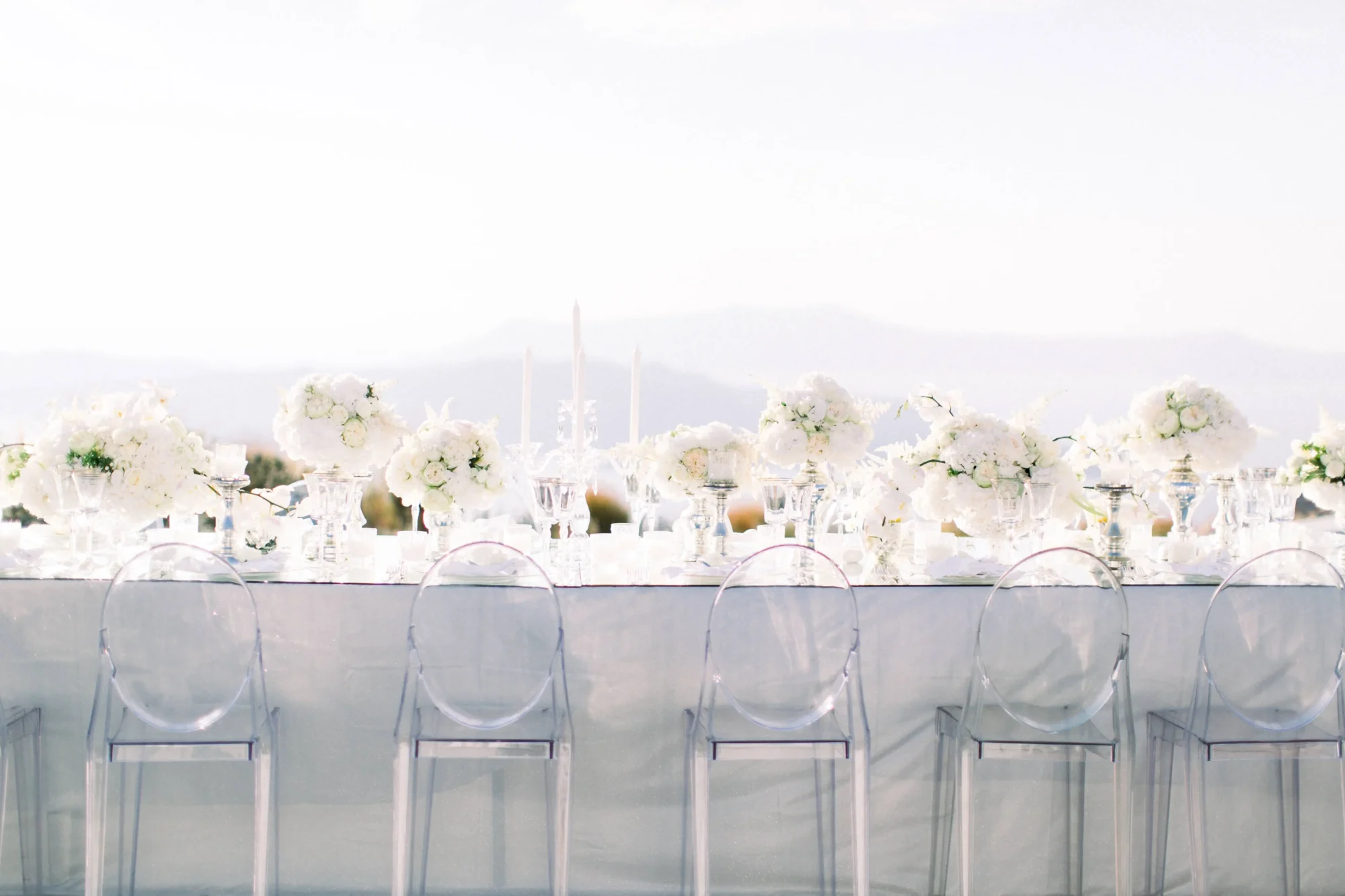 Elegant white wedding reception table setting in Santorini, Greece. Dream wedding decor.