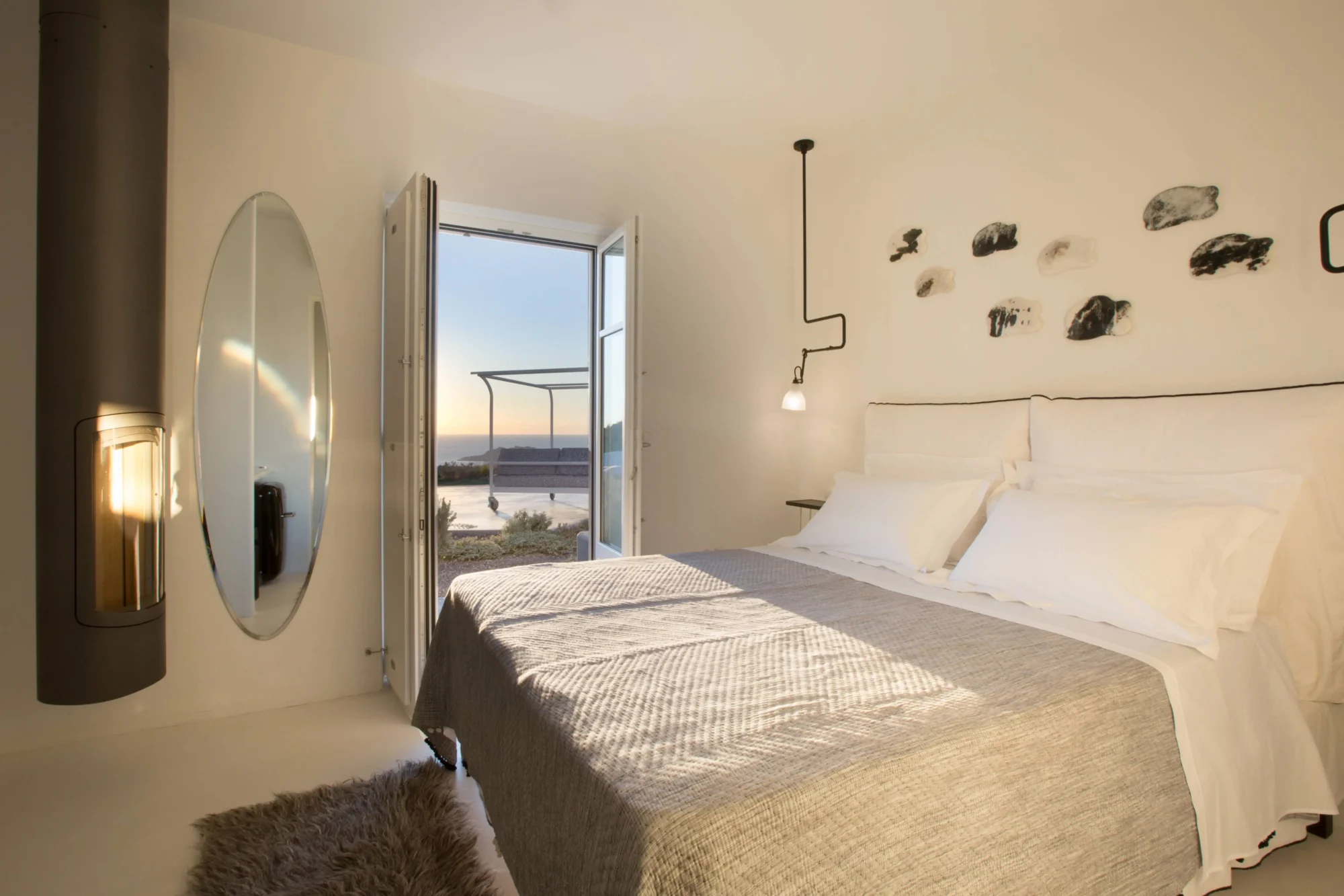 Santorini bedroom with fireplace, ocean view, and luxurious bed. Dream wedding location.