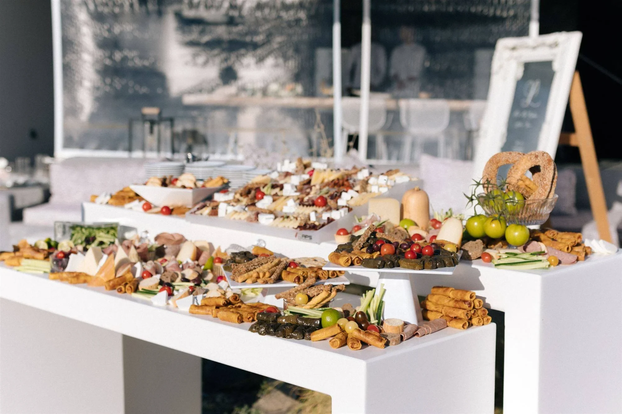 Lavish Santorini wedding buffet with cheeses, meats, and pastries. Dream wedding in Santorini.