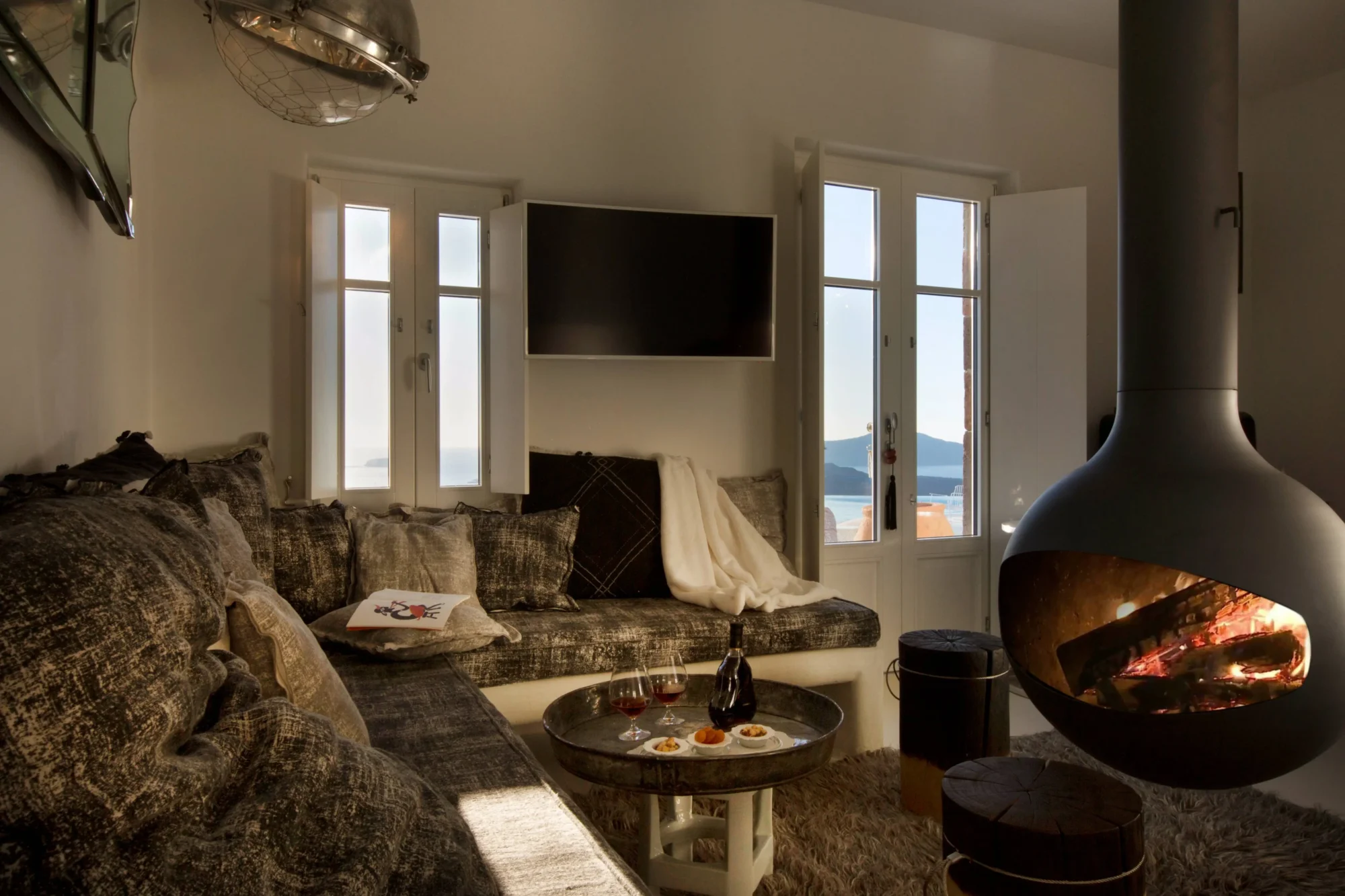 Cozy Santorini living room with fireplace, offering a dreamy view perfect for a wedding.