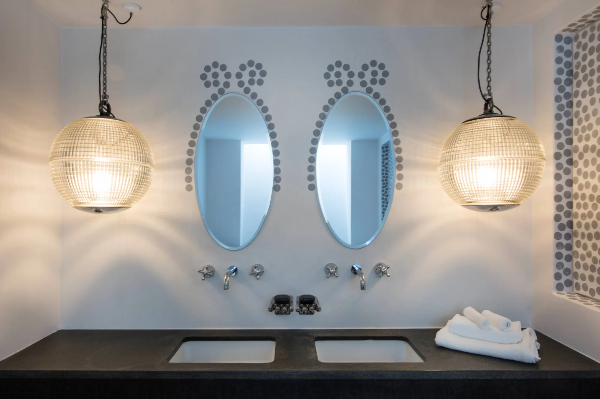 Luxurious double vanity with oval mirrors in a Santorini bathroom. Dream wedding setting.
