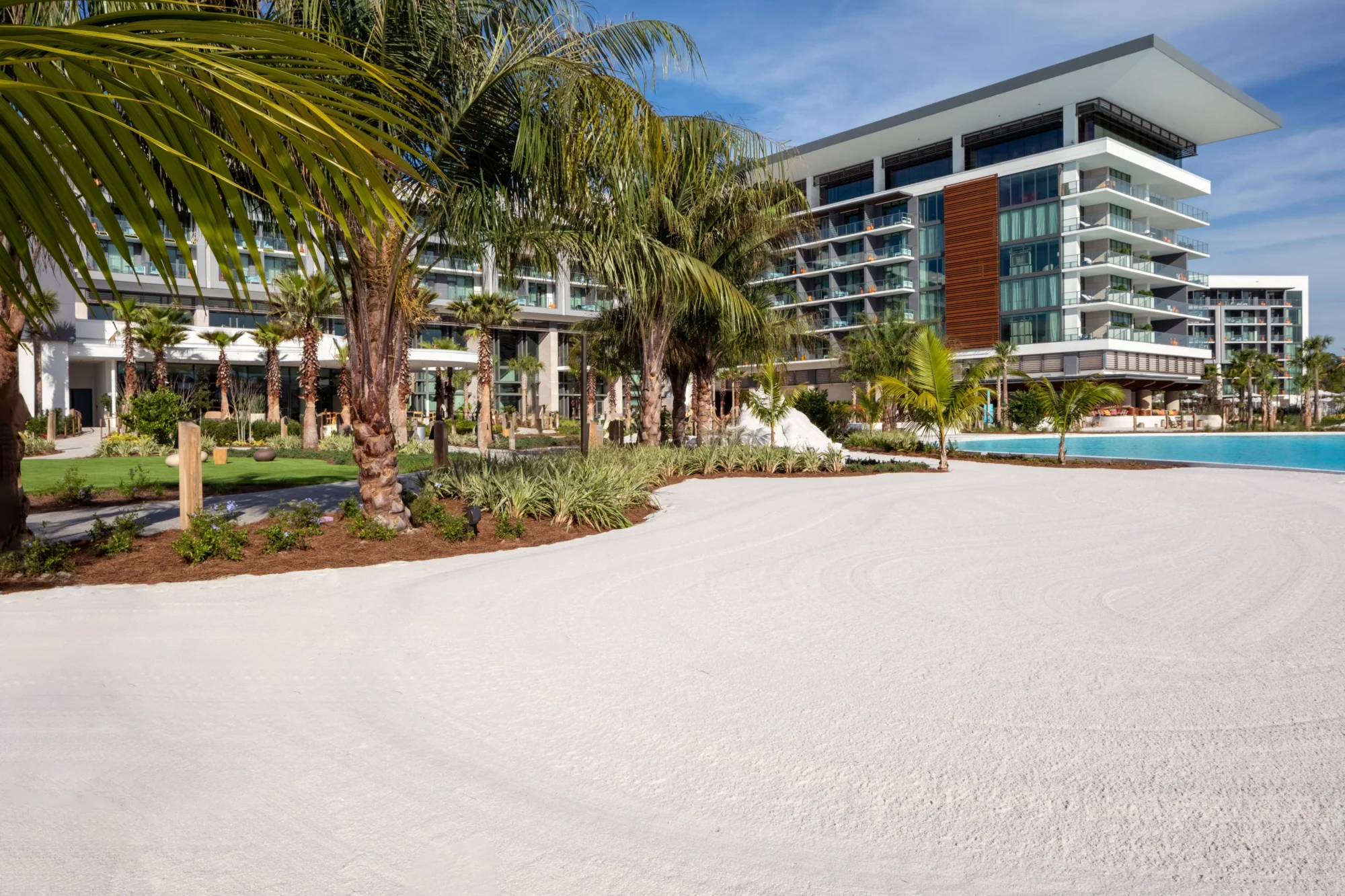 Luxury resort with white sand, palm trees, and a pool, perfect for an Orlando wedding destination.