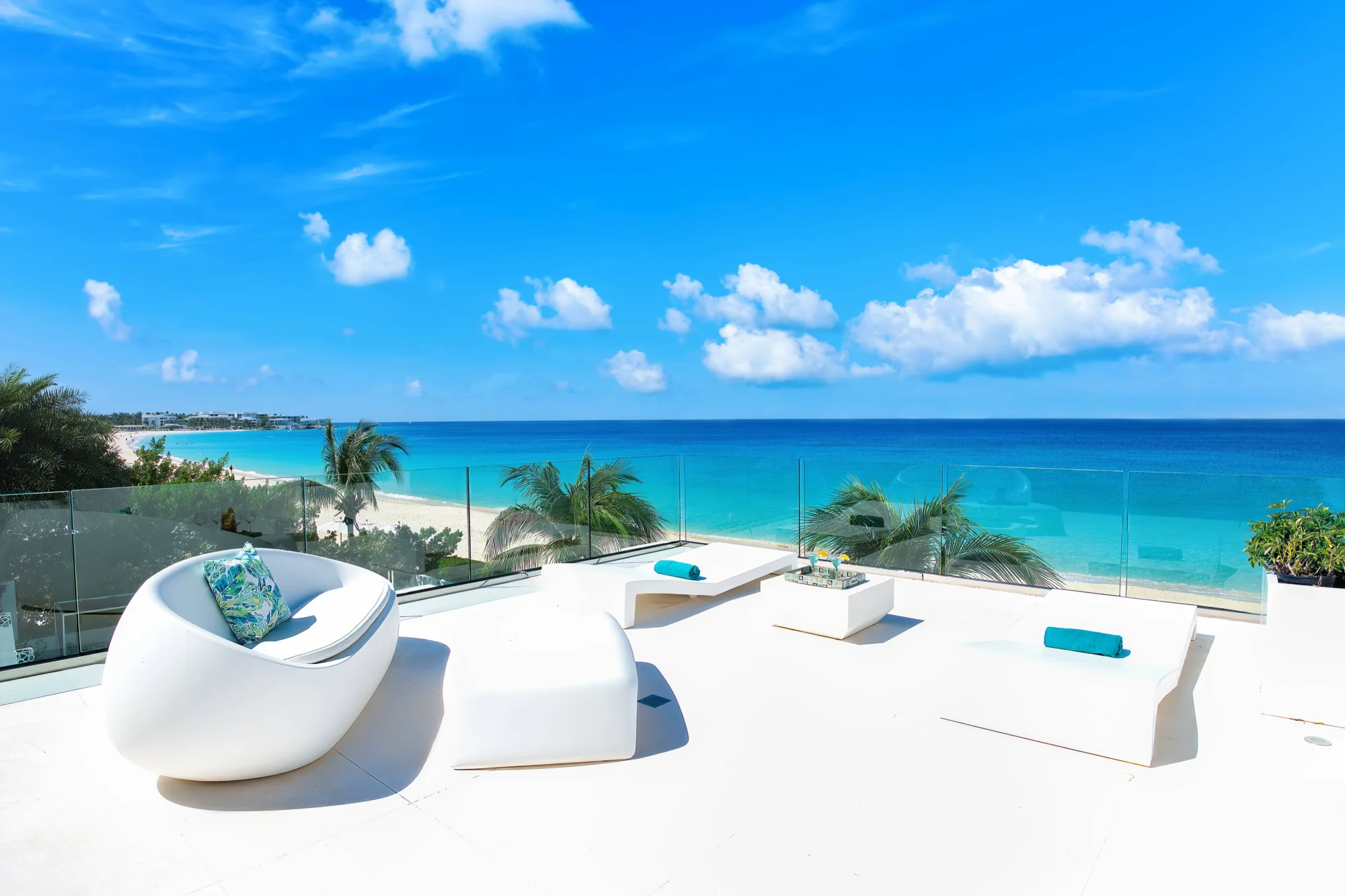 Luxury Anguilla beach house rooftop deck with white furniture overlooking turquoise ocean. Perfect for a destination wedding.