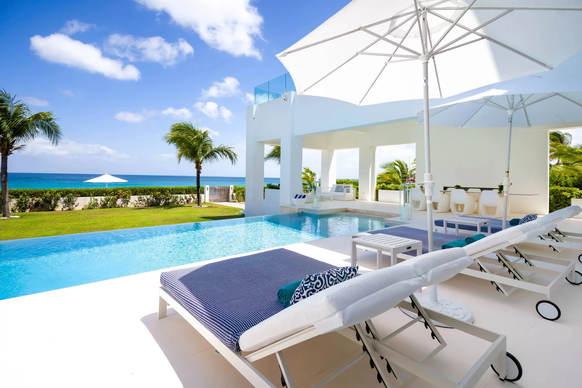 Luxury Anguilla beachfront villa with infinity pool, lounge chairs, and ocean views. Perfect for a destination wedding.