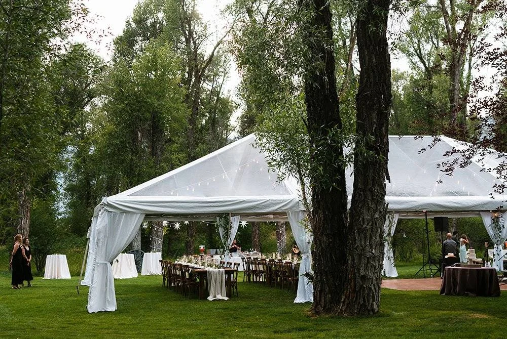 Wedding reception at Bentwood Inn in Jackson Hole, Wyoming. Tables set up under a clear tent.