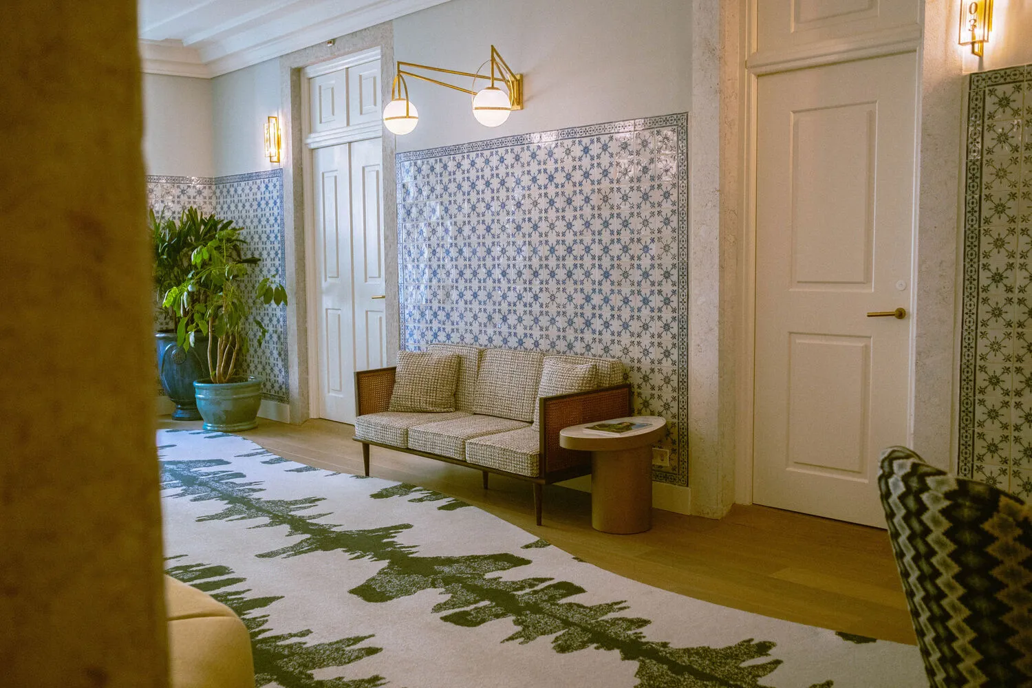 Elegant lounge area at Palácio Ludovice Hotel, featuring a patterned rug and comfortable seating.