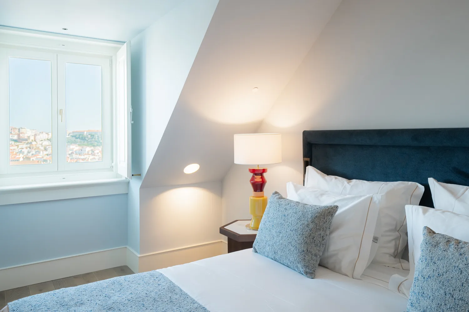 Cozy bedroom at Palácio Ludovice Hotel with city view.