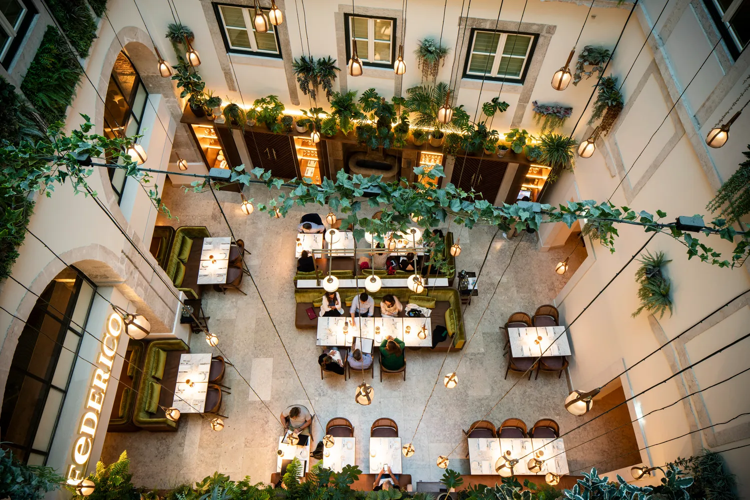 Overhead view of Palácio Ludovice's restaurant, featuring lush greenery and intimate dining spaces.