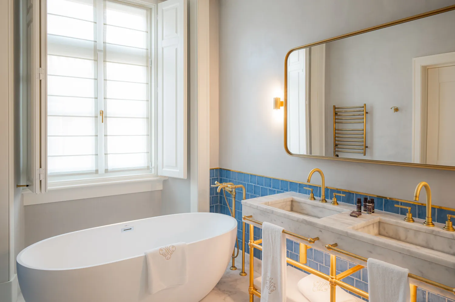 Luxurious bathroom at Palácio Ludovice Hotel featuring a freestanding tub and double vanity.