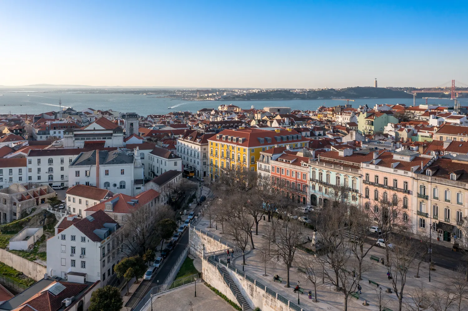Aerial view of Lisbon, Portugal, showcasing colorful buildings and a waterfront vista.