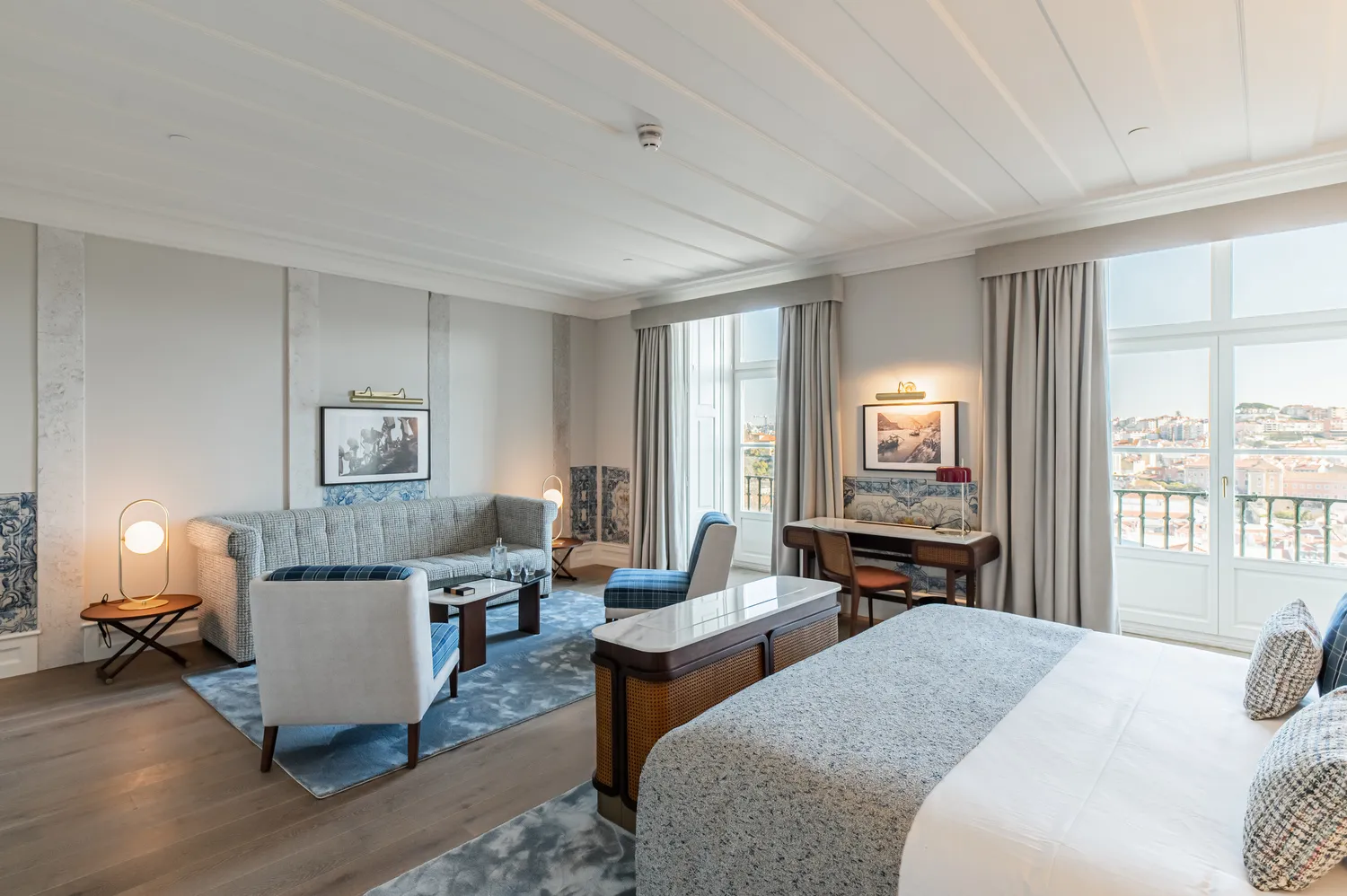 Luxurious suite at the Palácio Ludovice Hotel featuring a comfortable sitting area and a king-size bed.