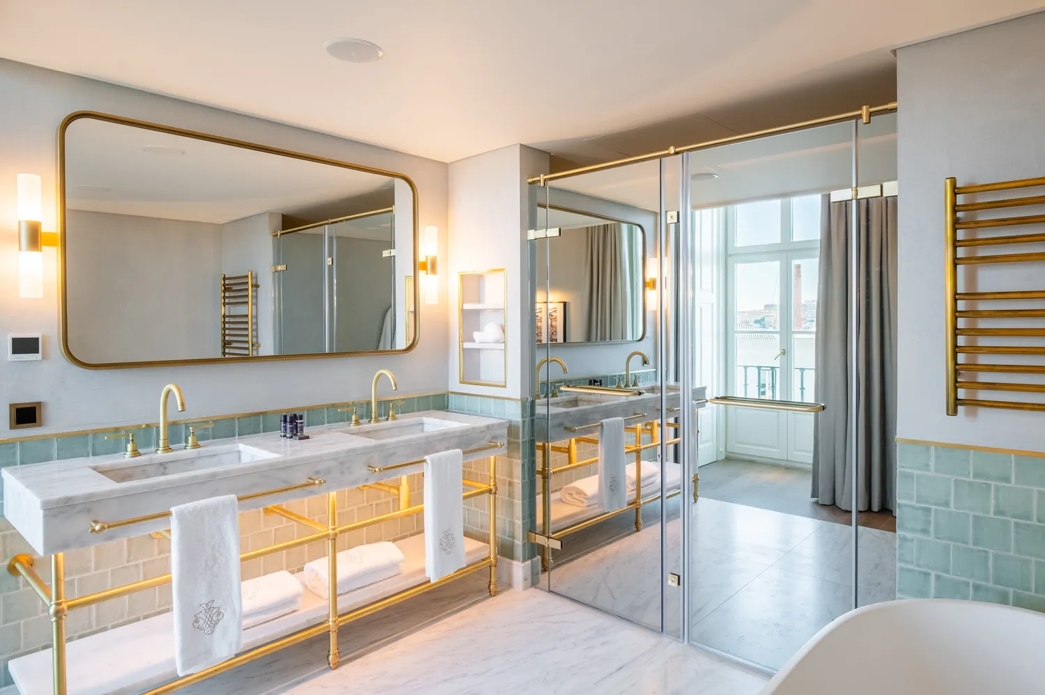 Luxurious bathroom at Palácio Ludovice Hotel with marble double vanity and gold accents.
