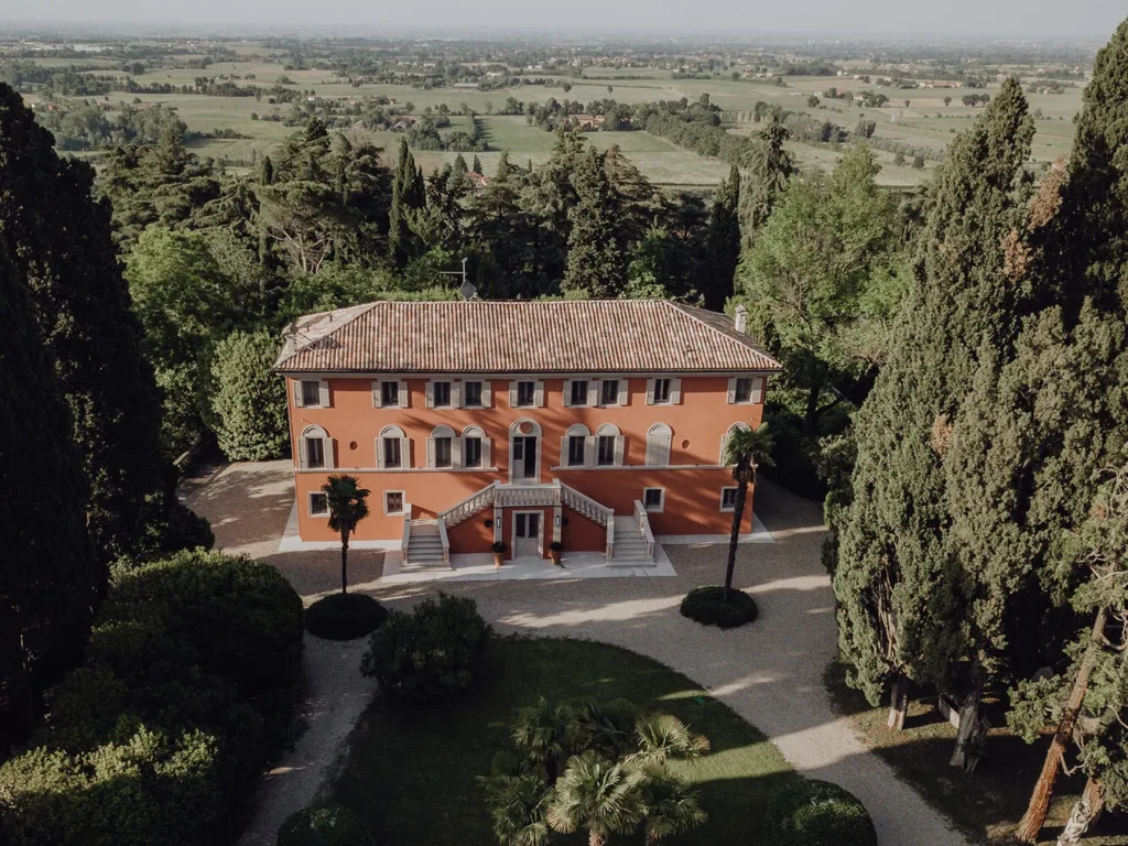 Aerial view of Relais Roncolo 1888, a stunning Italian wedding destination. Orange villa with manicured gardens.