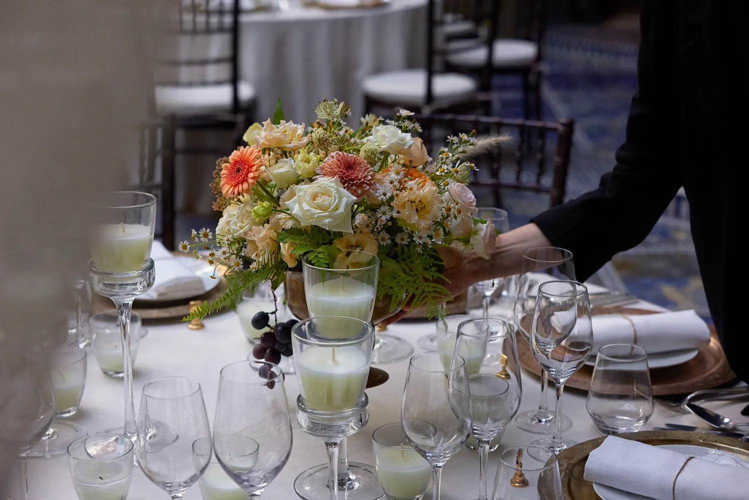 Elegant centerpiece with candles and flowers adorns a table set for a Royal Mansour Marrakech celebration.