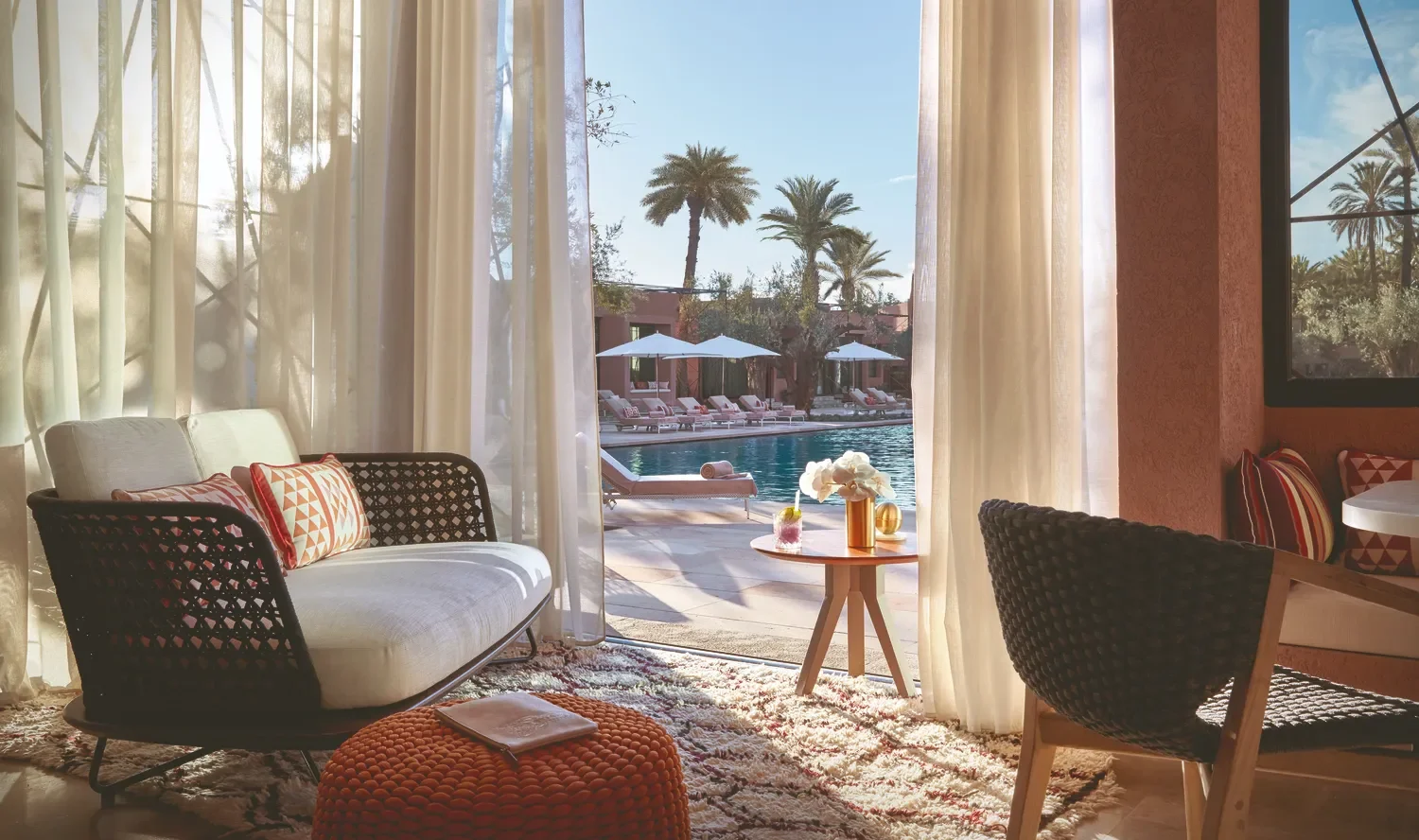 Relaxing suite at Royal Mansour Marrakech overlooking the pool and palm trees. Perfect for celebrations.