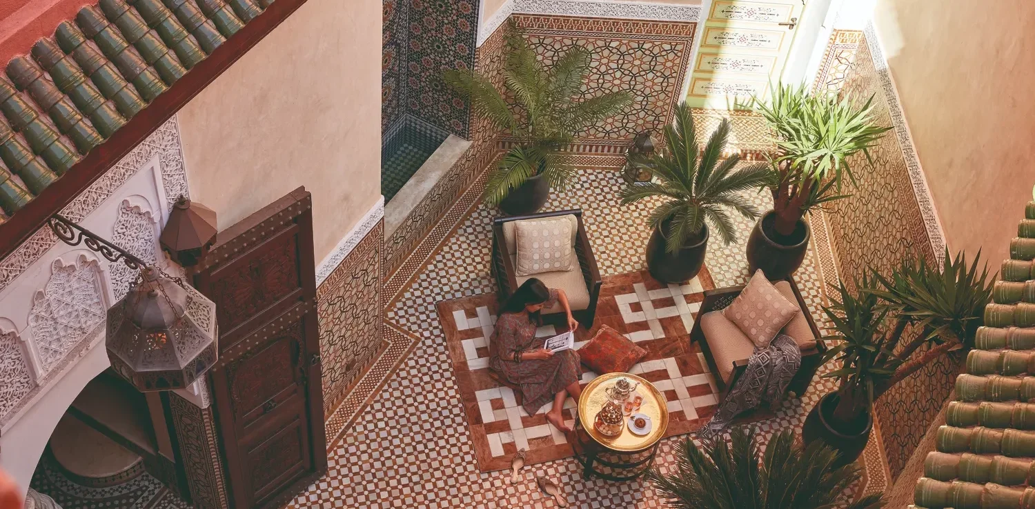 Woman relaxing in a luxurious Royal Mansour Marrakech courtyard.