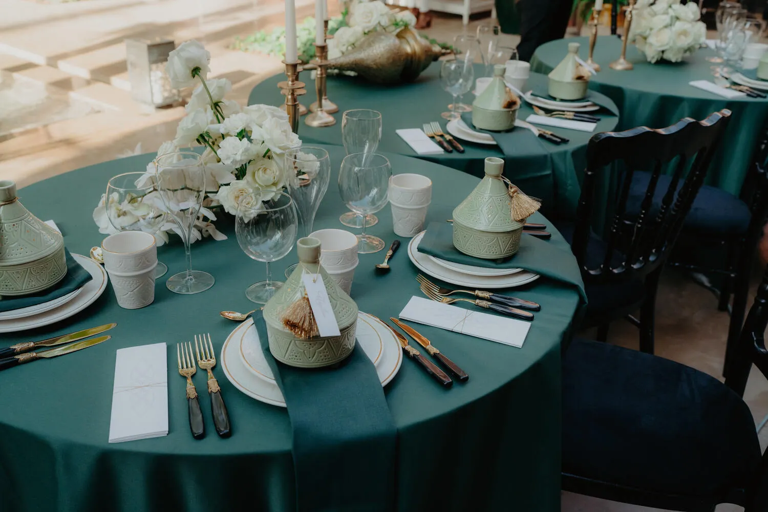 Elegant tablescape with green linens, gold flatware, and Moroccan tagines at a Royal Mansour Marrakech celebration.