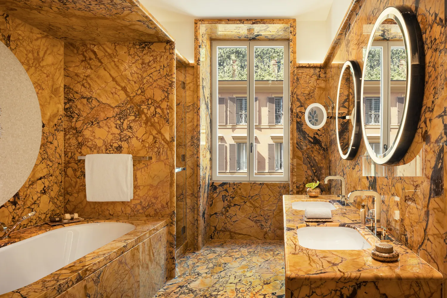 Luxury bathroom at the Bvlgari Hotel Roma, featuring marble finishes and a freestanding tub.