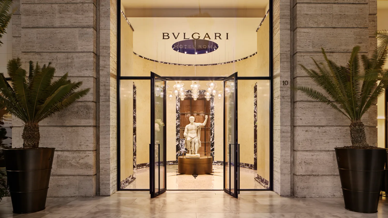Entrance to the Bvlgari Hotel Roma, featuring a classical statue.