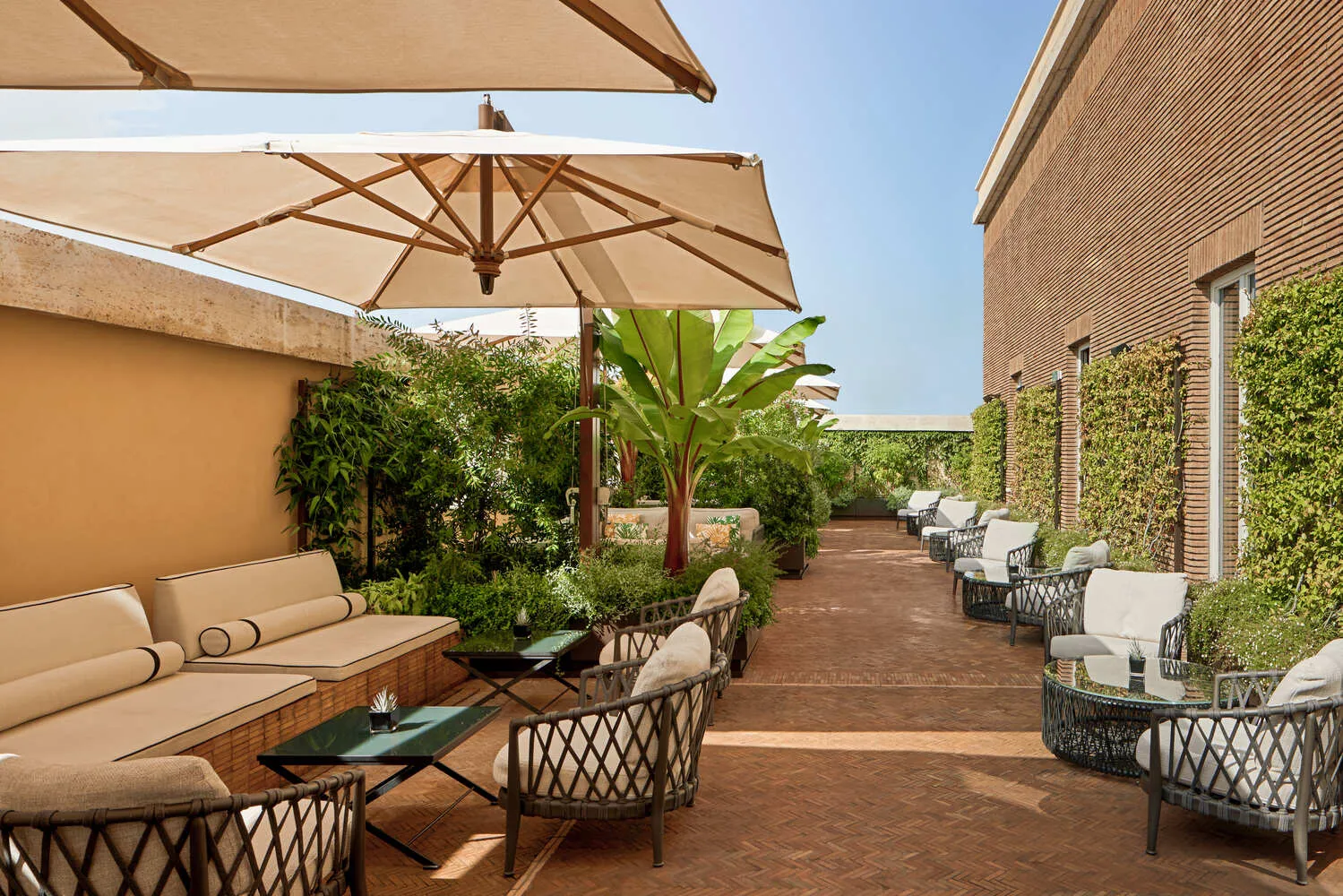 Outdoor patio at the Bvlgari Hotel Roma, featuring comfortable seating and lush greenery. Perfect for a luxurious wedding.