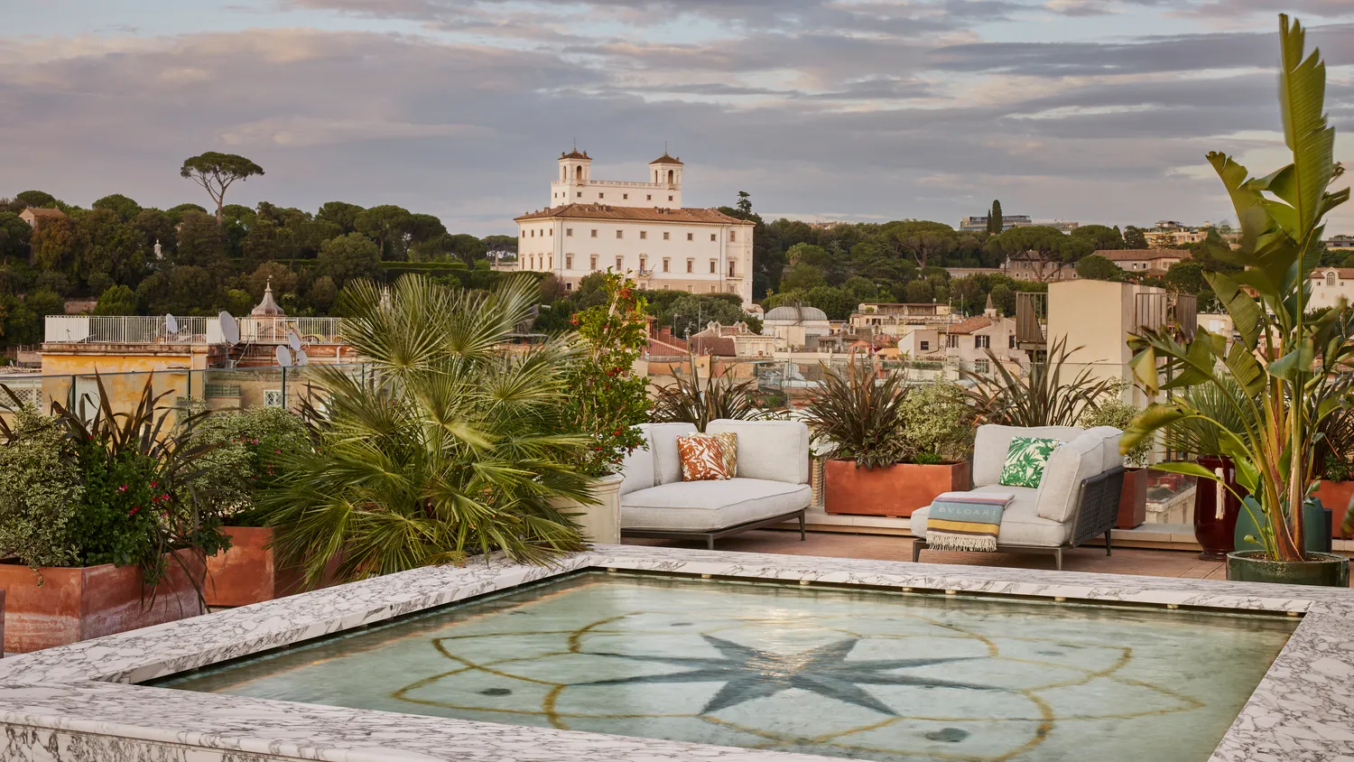 Luxury rooftop terrace at the Bvlgari Hotel Roma, featuring a reflecting pool and comfortable seating. Perfect for a romantic wedding.