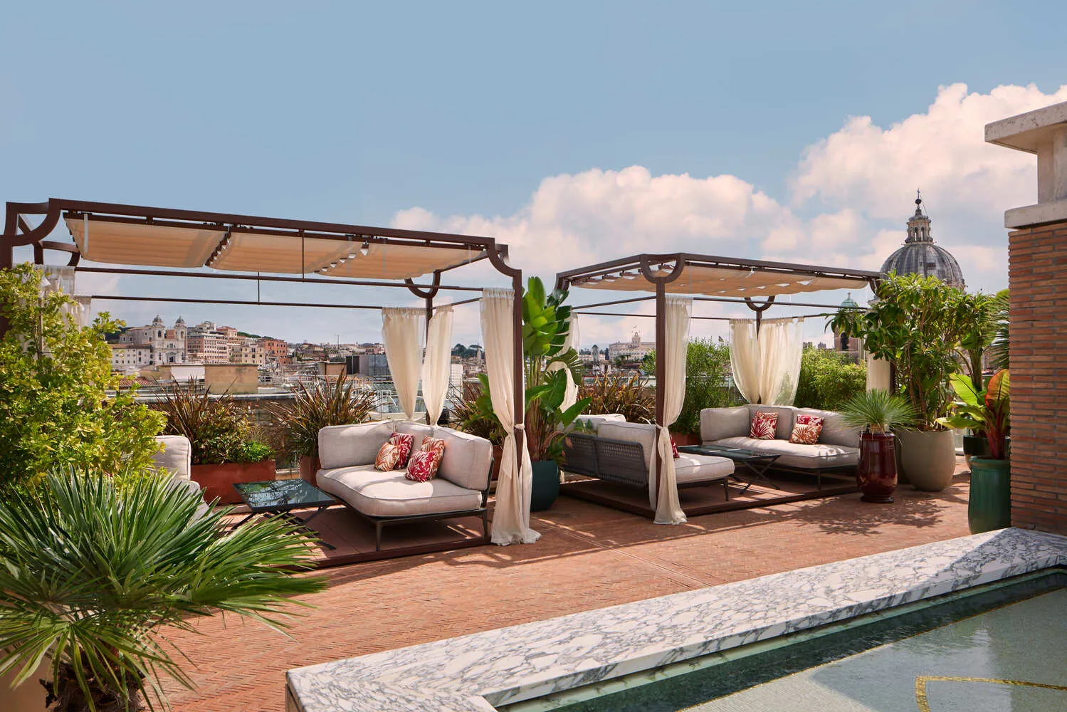 Luxury rooftop terrace at the Bvlgari Hotel Roma, featuring comfortable lounge seating and stunning city views. Perfect for a romantic wedding.