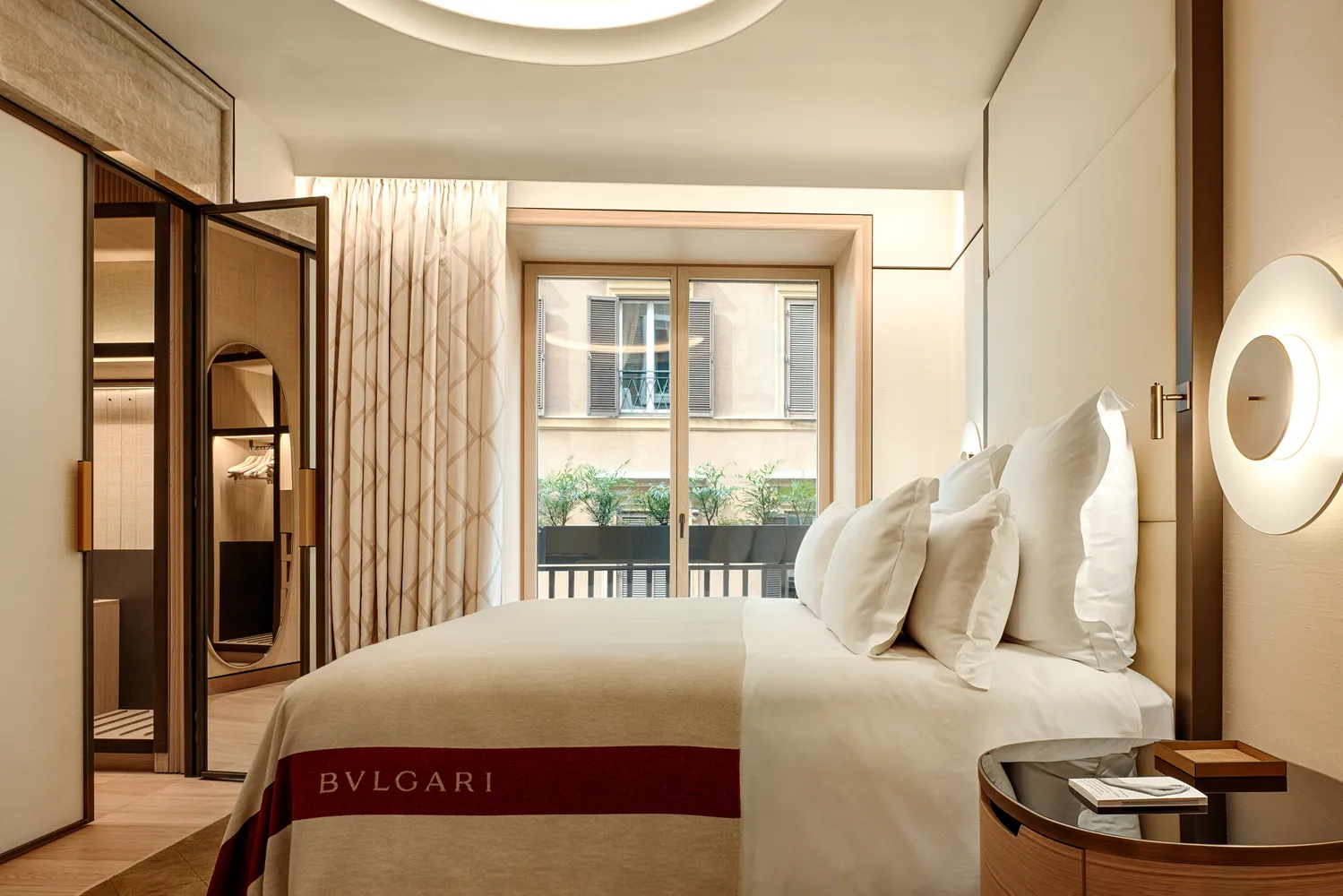 Luxurious Bvlgari Hotel Roma bedroom with king-size bed and city view.
